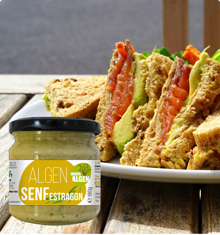 Viva Maris ALGEN Bio Senf Estragon im Glas vor einem Sandwich mit Tomate, Avocado und Senf