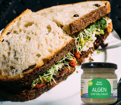 Bio Algen Senf Dill Sauce im Glas neben einem Sandwich