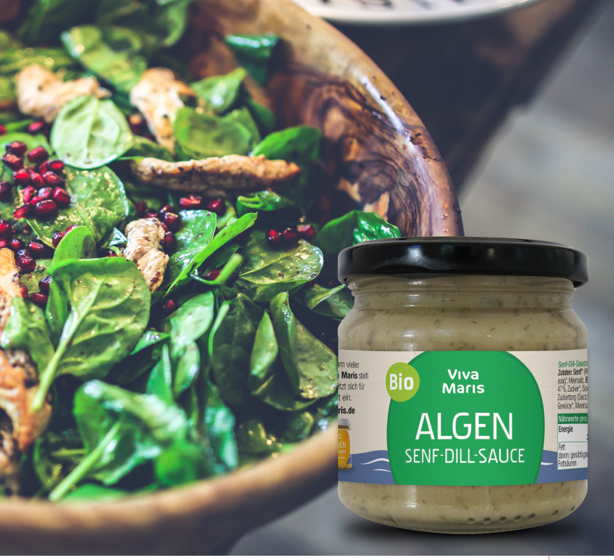 Viva Maris ALGEN Bio Senf-Dill Sauce im Glas neben einer Schüssel Feldtalat und Granatapfel Kernen