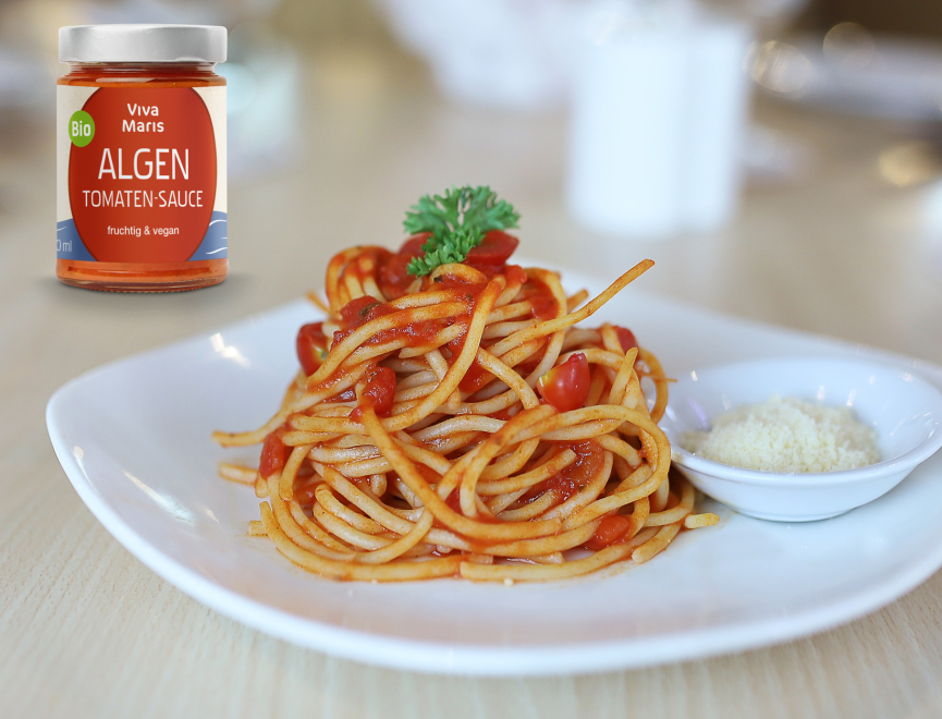 Bio Algen Tomaten-Sauce im Glas vor einem Schüssel mit Spaghetti und Algen Tomaten Sauce